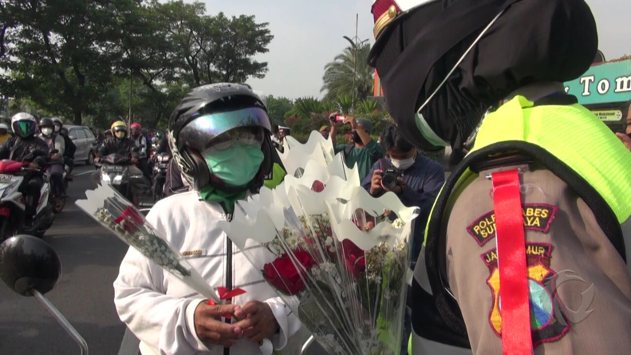 Anggota Satlantas Polrestabes Surabaya membagikan bunga ke pengguna jalan di hari pertama Operasi Zebra, Senin (26/10/2020)