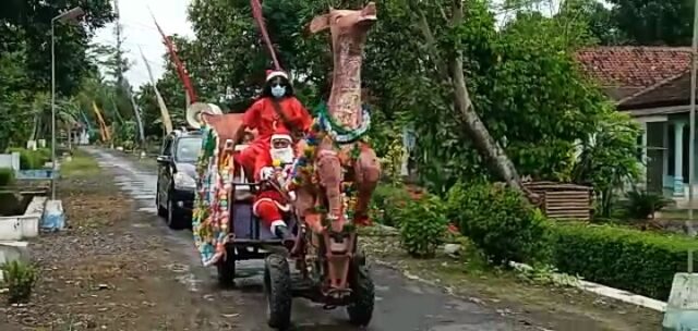 Natal 2020, Naik “Kereta Rusa” Sinterklas Bagikan Bingkisan ke Rumah Warga di Jember