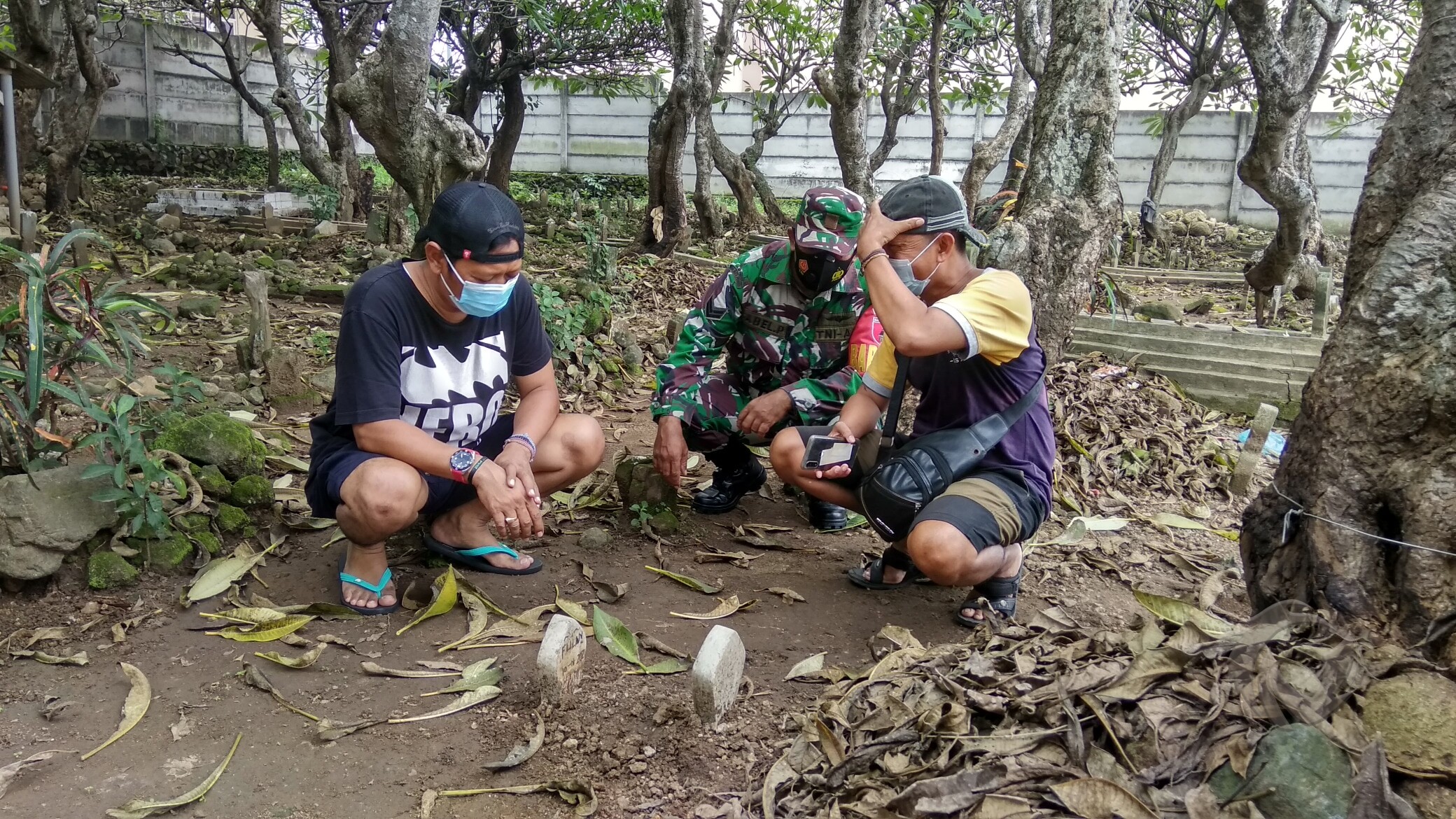 Warga dan pihak Koromil Kutorejo meninjai lolasi penemuan makam misterius yang berada di TPU Desa Sampangagung, Kecamatan Kutorejo, Kabupaten Mojokerto, Sabtu (16/01/2021).