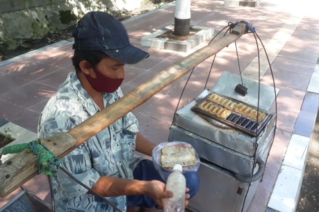 Suprapto, pedagang kue rangin saat mangkal di Jalan Kesatrian Samping Komplek Makodam V Brawijaya, Kamis (8/12/2021)
