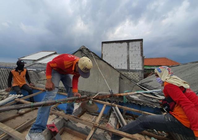 Pekerja DPRKP-CKTR Surabaya perbaiki atap rumah warga yang rusak akibat hujan deras dan angin kencang