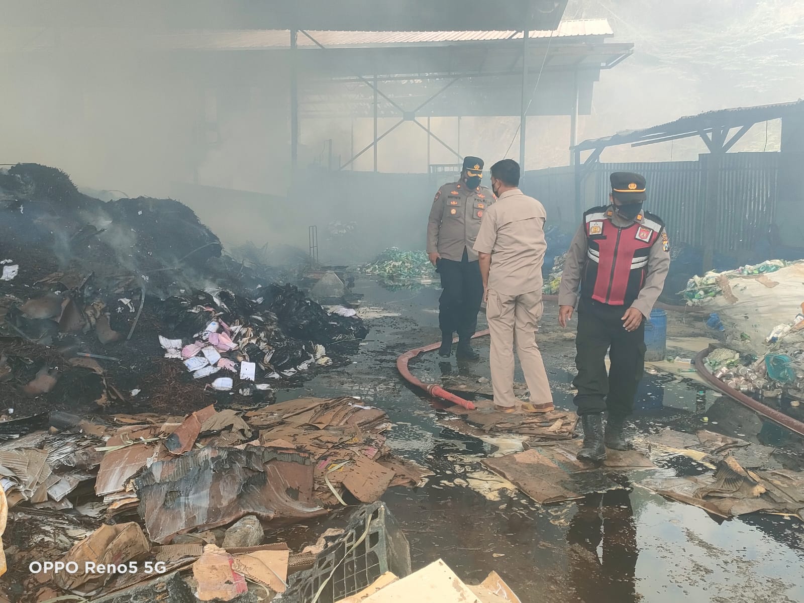 Pihak kepolisian saat meninjau gudang pemusnahan limbah milik PT Hijau Alam Nusantara (HAN) yang terbakar, Kamis (14/7/2022).