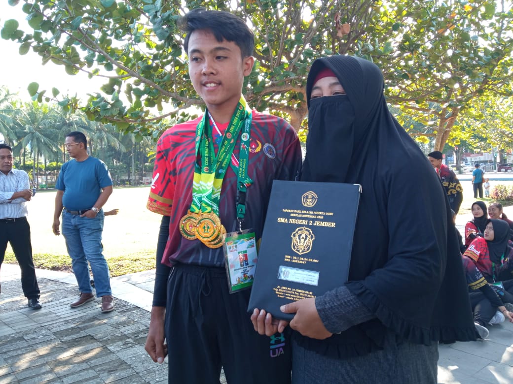 Muhammad Ihsan Maulana saat didampingi ibunya menerima medali emas dari Cabor Drumband.